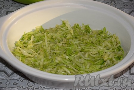 Далее берем жаропрочную форму (я взяла жаропрочную керамическую форму объёмом 1 литр). В форму, не смазанную маслом, первым слоем выкладываем половину капусты, смешанной с кабачками, и равномерно распределяем по дну формы.
