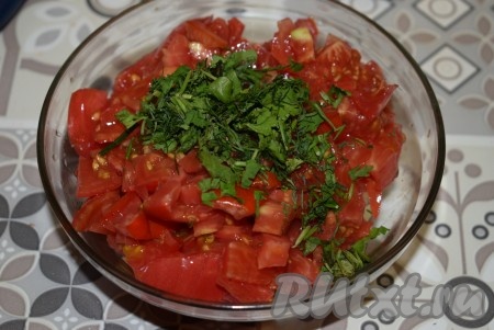 Помидоры нарезаем на кубики. В глубокую миску отправляем нарезанные помидоры, острый перчик (если готовите с ним) и зелень с чесноком.
