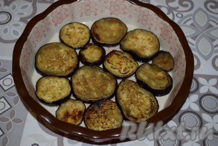 Далее берём глубокую тарелку (или форму), так как в процессе пропитки наша закуска из баклажанов с помидорами и чесноком выделит очень много сока. На дно формы первым слоем выкладываем кружочки баклажанов.
