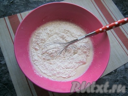 Замешивая тесто с помощью венчика, всыпать частями муку с разрыхлителем.
