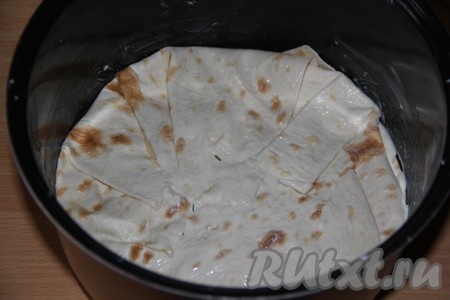 Накрыть лавашом, который свисает с краёв мультиварки, и слегка прижать.
