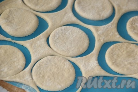 Готовое тесто, замешанное руками или с помощью хлебопечки, обмять, а затем на поверхности, немного присыпанной мукой, раскатать в пласт толщиной 0,5 см. С помощью круглой вырубки вырезать кружочки. От размера кружочка зависит размер ваших булочек-бантиков.
