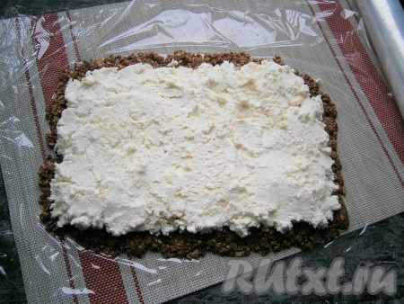 Поверх массы из печенья выложить творожную массу и также аккуратно её разровнять по всему печенью.
