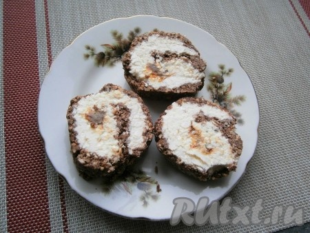 Отправить рулет из печенья с творогом в морозилку на 1 час. После этого рулет можно нарезать на части, используя острый нож. Основа из печенья будет немного крошиться, но режется рулет нормально.
