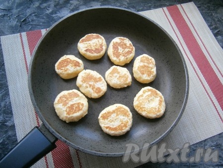 Готовить печенье на небольшом огне под закрытой крышкой до румяности с двух сторон (в общей сложности понадобится около 5 минут жарки для каждой стороны, но печенье нужно раза 2-3 перевернуть в процессе обжаривания). Затем готовое творожное печенье переложить на тарелку. Таким образом пожарить все печенюшки.
