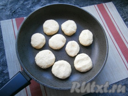 По прошествии времени развернуть плёнку. Каждую колбаску из теста нарезать острым ножом на шайбочки толщиной около 1 см. Каждую шайбочку чуть придавить рукой. Выложить творожное печенье на разогретую сухую сковороду.
