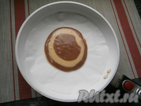 Дно сковороды с высокими бортиками диаметром 26 см застелить пергаментом. Выкладывать тесто в центр сковороды столовой ложкой поочередно: столовую ложку светлого, на него - столовую ложку тёмного.
