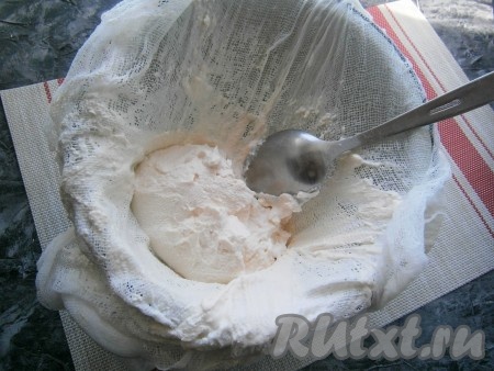Когда вы увидите, что уже ряженка полностью разморозилась и получился сыр, а в кастрюлю стекла сыворотка, нужно свернуть концы марли так, чтобы она полностью закрыла сыр. Поверх творожного сыра, завёрнутого в марлю, поставить небольшой гнёт (например, банку с водой) и оставить на пару часов, чтобы оставшаяся сыворотка полностью стекла в кастрюлю.
