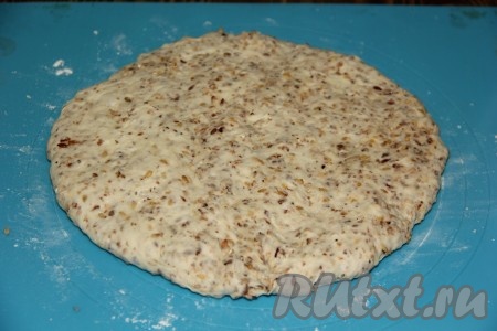 Выложить тесто на силиконовый коврик (или на другую поверхность), присыпанный мукой, и хорошо обмять. Тесто практически не липнет к рукам, при желании, можно смазать руки маслом. Сформировать круглую лепёшку.