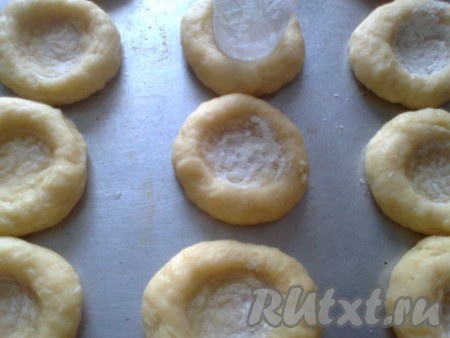 Противень смазать растительным маслом (или застелить пергаментом). Выложить шарики на противень. В центре каждого шарика сделать углубление с помощью стакана.