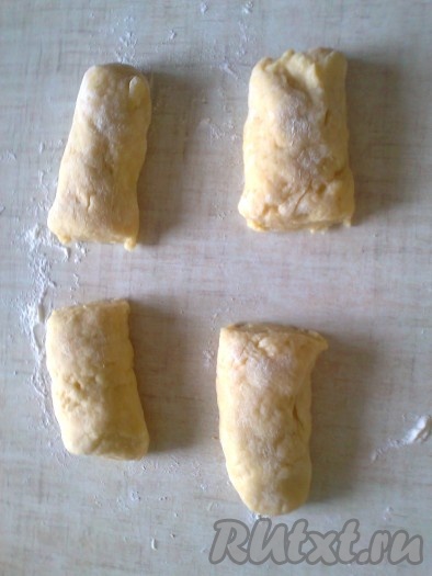 Готовое тесто выложить на стол, слегка присыпанный мукой, и хорошо обмять. Раскатать тесто в виде колбаски. Разделить на 4 части.
