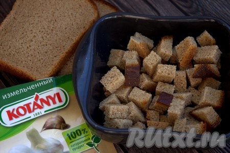 Ломтики чёрного хлеба нарезать на небольшие кубики, выложить в форму для запекания, по желанию, посыпать специями (у меня - гранулированный чеснок), перемешать, выложить в один слой на противень и отправить в заранее разогретую до 150 градусов духовку на 25-30 минут (время сушки зависит от размера сухарей, поэтому периодически проверяйте готовность сухариков и перемешивайте). Готовые сухарики достать из духовки и дать им остыть.