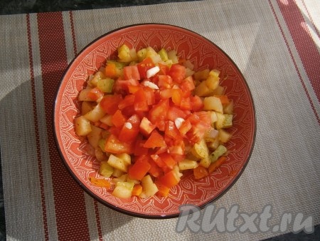 Далее добавить измельчённый чеснок и нарезанный кубиками помидор, влить растительное масло, снова перемешать и отправить овощное рагу, прикрыв крышкой, в микроволновку ещё на 5 минут.
