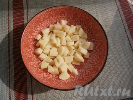 Картошку, морковь, чеснок и лук очистить. Если у кабачка нежная кожица и маленькие семечки, их можно оставить и готовить вместе с ними. В глубокую толстостенную миску, которая пригодна для готовки в микроволновке, выложить картофель, нарезанный небольшими кубиками, затем влить воду и отправить в СВЧ на 5 минут при мощности 750 Ватт, прикрыв миску крышкой с выходом пара.
