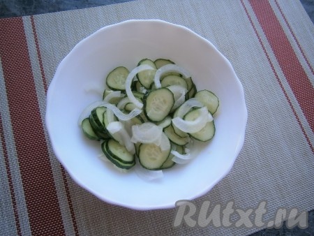 Добавить очищенный и нарезанный полукольцами репчатый лук, перемешать с огурчиками.
