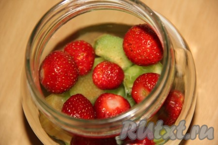 Вначале нарезанный ревень равномерно разложить по стерильным банкам. Затем разложить равномерно клубнику по баночкам. Банки должны быть заполнены на половину объёма.