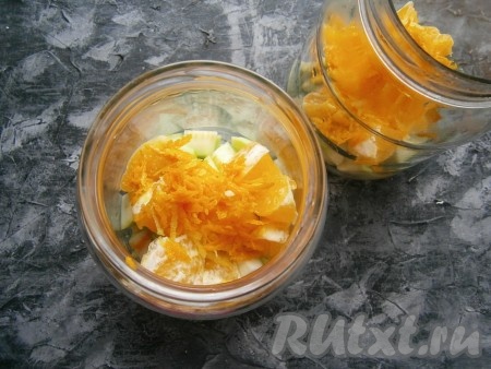 По чистым простерилизованным банкам равномерно разложить кусочки кабачков и апельсинов, а также цедру лимонов и апельсинов.
