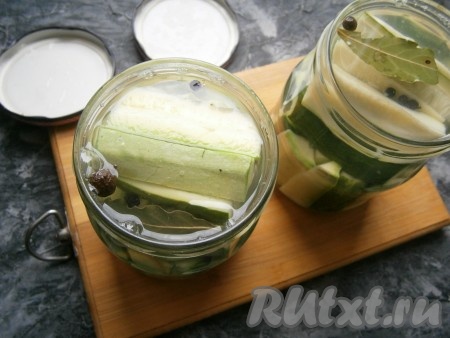 Огонь выключить, а горячий маринад влить в банки с кабачками и огурцами, заполняя баночки до горлышка.
