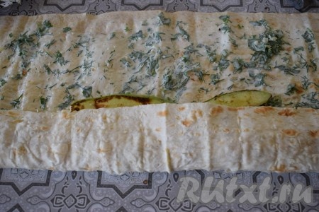 Далее, начиная со стороны с кабачками и фаршем, плотно сворачиваем лаваш в рулет.