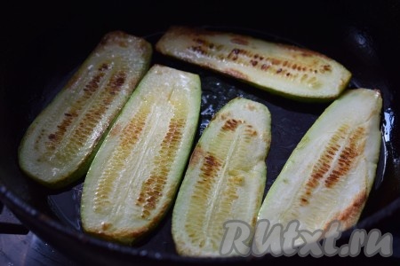 Жарим кабачки до румяного цвета на среднем огне с двух сторон (примерно, по 3 минуты). Готовые кабачки снимаем со сковороды и выкладываем на тарелку. Таким образом обжариваем все полоски из кабачков и, переложив их на тарелку, даём им остыть.
