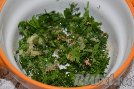 Пока просаливается фарш, подготовим соус для смазки лаваша. Для этого зелень нарезаем мелко, отправляем в пиалу. Чеснок пропустим через чеснокодавку и добавим к зелени, посолим и поперчим наш соус.