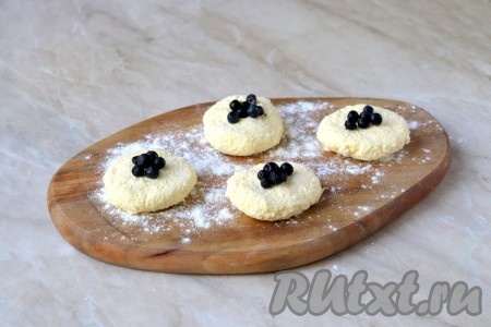 Из творожной массы сделайте небольшие лепёшки. По центру выложите, примерно, по 5-6 ягодок.&nbsp;
