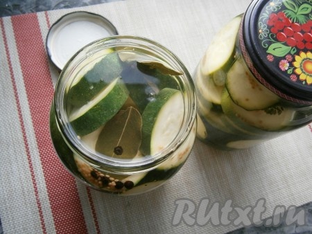 Слить из банок второй раз воду в раковину и сразу залить кабачки в банке кипящим маринадом, заполняя баночки до самого верха.
