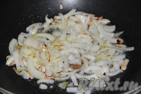 В это же время ставим вторую сковороду, выкладываем в неё предварительно очищенный и не крупно нарезанный лук, обжариваем на среднем огне, иногда перемешивая, до золотистости.