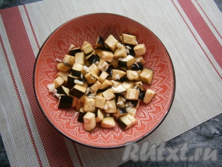 По прошествии 15 минут баклажаны отжать от выделившейся жидкости и разместить их в небольшой форме (или миске), перемешать с мелко нарезанным чесноком и оливковым маслом.
