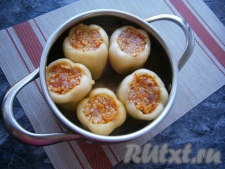 У болгарских перцев удалить хвостики и семена, наполнить их подготовленной начинкой. Поместить перцы вертикально в кастрюлю с толстым дном (или в казанок), влить кипяток на 1/3-1/2 высоты перцев и поставить на огонь.