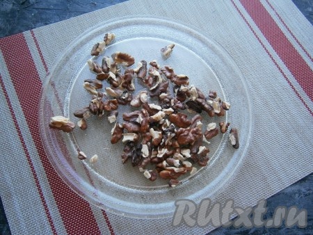 Ядрышки грецких орехов обжарить на небольшом огне на сухой сковороде, иногда помешивая, до лёгкого жареного аромата (3-4 минуты) или подсушить в микроволновке в течение 2-3 минуты при мощности 750 Ватт.
