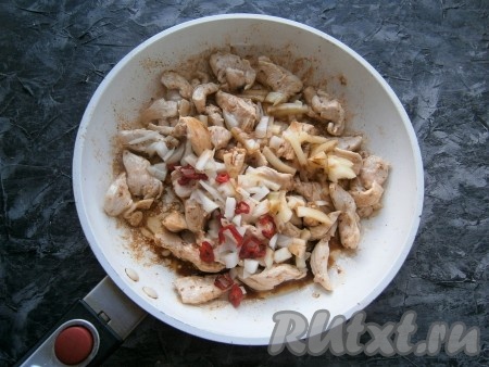 Обжарить курицу, помешивая, на среднем огне в течение 3-4 минут, затем добавить мелко нарезанные лук и перец чили (если хотите получить менее острое блюдо, семечки из перца чили можно удалить), а также болгарский перец, нарезанный соломкой, влить соевый соус.
