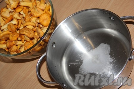 Лисички перебрать, удалить листочки и траву. Промыть грибы под проточной водой. Если грибочки крупные, то можно их разрезать на 2 части. У меня маленькие грибочки. В кастрюлю влить воду, всыпать соль и сахар.
