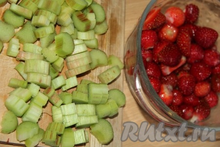 Клубнику очистить от листиков, промыть, немного обсушить, выложив, например, на бумажное полотенце, затем, если ягодки очень крупные, их можно разрезать на несколько частей. Стебли ревеня вымыть, снять с них тонкую плёнку, очищая стебельки по всей длине, а затем нарезать на кусочки.