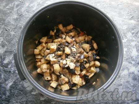 После окончания программы выложить в чашу мультиварки баклажаны, отжатые от жидкости, добавить соль, нарезанный кусочками чеснок, чёрный молотый перец, сушёный базилик.