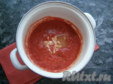 Томат в кастрюле довести до кипения, добавить соль, растительное масло, сахар и нарезанные кусочками очищенные зубчики чеснока, снова довести до кипения.
