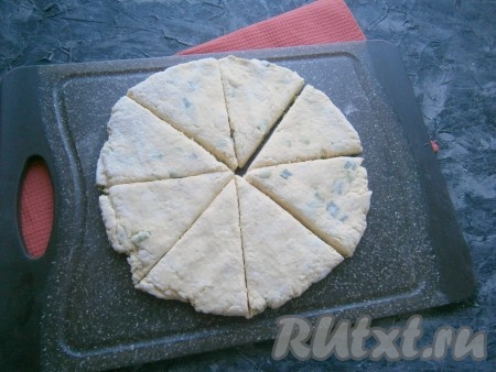 Немного муки насыпать на поверхность стола, руками сформировать лепёшку толщиной около 0,5 см. Разрезать её на 8 частей (секторов).
