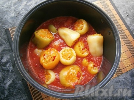 Довести соус до кипения на газу (или в мультиварке на режиме "Варка"). В закипевший соус выложить перец, фаршированный овощами и рисом.