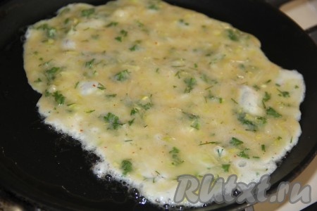 Сковороду хорошо разогреть и смазать растительным маслом. Вылить на сковороду 2 столовые ложки яично-кабачковой массы и равномерно распределить. Жарить на среднем огне.
