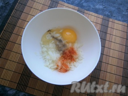 К луку добавить сырое яйцо, соль, всыпать паприку и чёрный молотый перец.
