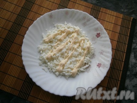 Яйца разделить на белки и желтки. На круглую тарелку выложить первым слоем натёртые на крупной тёрке белки (половинку одного белка оставить для украшения). Белки покрыть полосочками майонеза (не придавливать слой белков и не смазывать этот слой майонезом с помощью ложки - нужно, чтобы слой белков получился достаточно воздушным).
