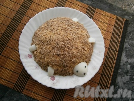 От оставшегося яичного белка отрезать третью часть с узкой стороны, вставить глазки и ротик из перца горошком, имитируя голову черепашки, разместить голову на краю салата. Остальную часть белка нарезать на небольшие плоские кусочки и вставить с чётырех сторон в салат в виде лапок черепашки (см. фото).
