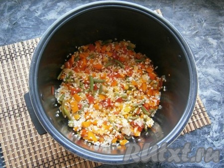 Всыпать подготовленный рис, перемешать его с обжаренными овощами.
