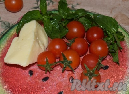 Подготовим продукты для приготовления закуски. Помидоры черри и базилик промоем в холодной воде, у помидоров удалим плодоножки, а базилик разберём на листочки.

