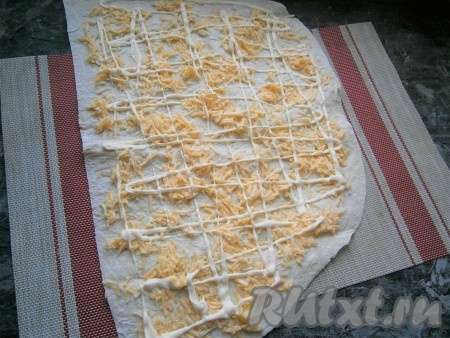 Второй лист лаваша разрезать пополам и каждую половину смазать полученной яично-сырной смесью, оставляя края чистыми. Нанести по всему лавашу сетку из майонеза.
