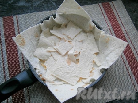 Оставшиеся обрезки первого лаваша порвать руками и разместить сверху сыра.
