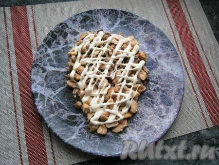 Куриное филе с грибами остудить и выложить на большую плоскую тарелку в виде головы быка, нанести щедрую сеточку из майонеза.
