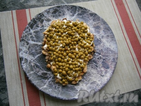 Следующим слоем выложить консервированный горошек.