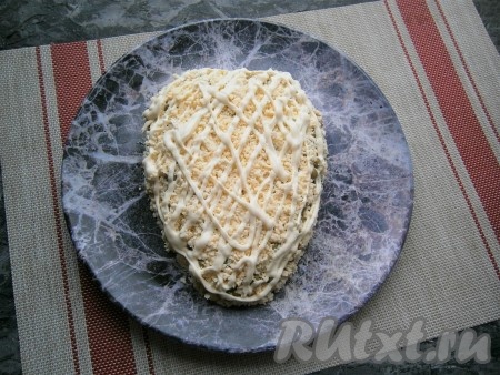 Яйца разделить на белки и желтки. Желтки натереть на тёрке и выложить их третьим слоем, посолить и нанести майонез в виде сеточки.
