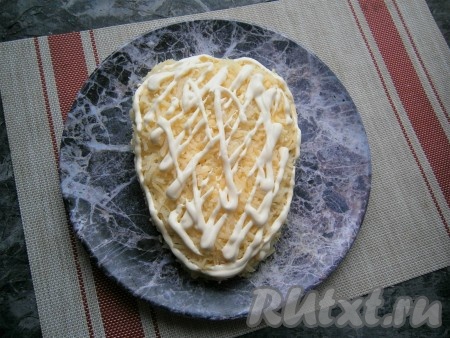 Далее идёт слой натёртого на средней (или мелкой) тёрке картофеля, немного посолить, смазать сеточкой из майонеза.
